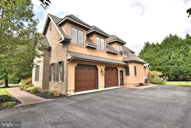 view of front of property featuring stucco siding, a garage, and aphalt driveway