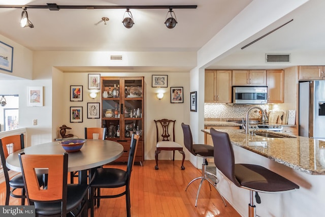 dining room featuring light hardwood / wood-style flooring and sink