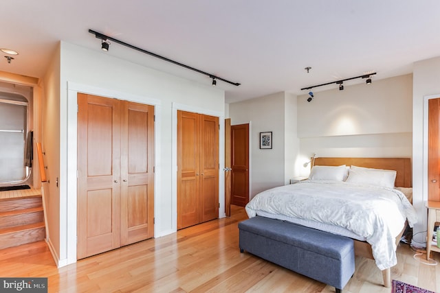 bedroom with light hardwood / wood-style flooring and track lighting