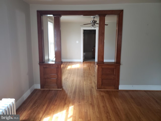 hallway with light wood-type flooring and radiator heating unit