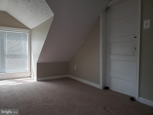 bonus room with a textured ceiling, carpet, and vaulted ceiling