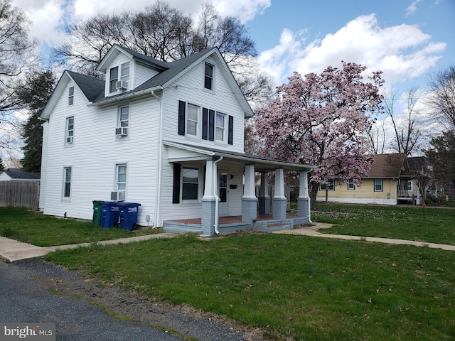 view of front property with a porch, a front lawn, and central air condition unit