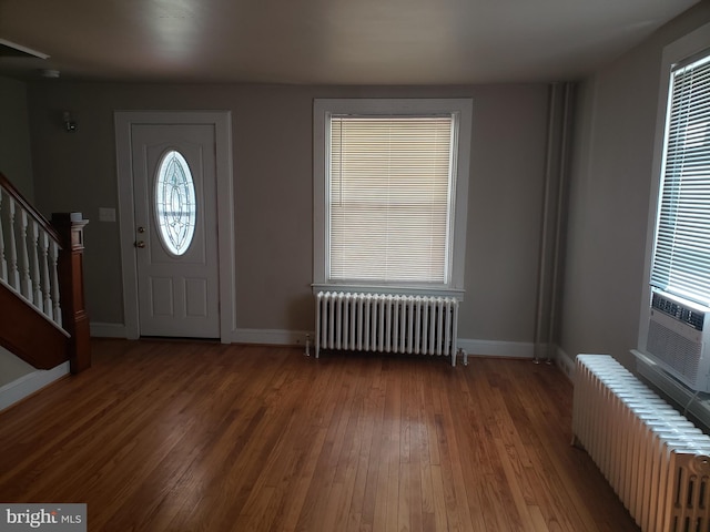 entrance foyer featuring dark hardwood / wood-style flooring and radiator heating unit