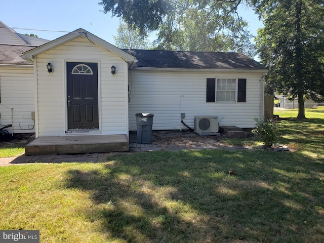 rear view of property with a lawn and ac unit