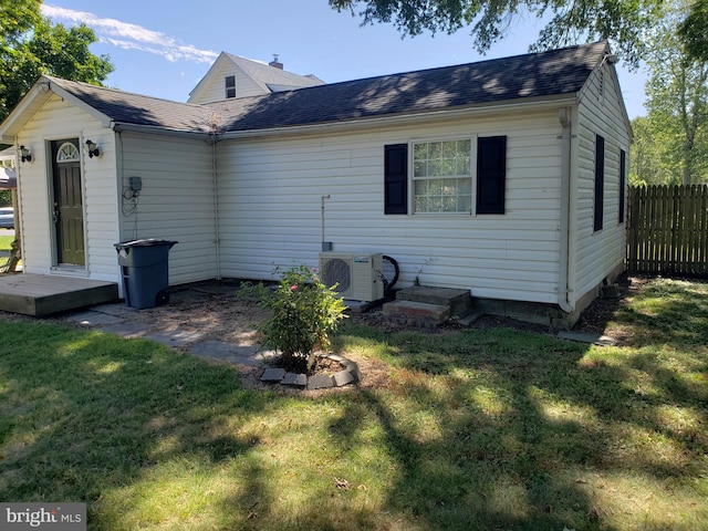 back of house featuring ac unit and a lawn