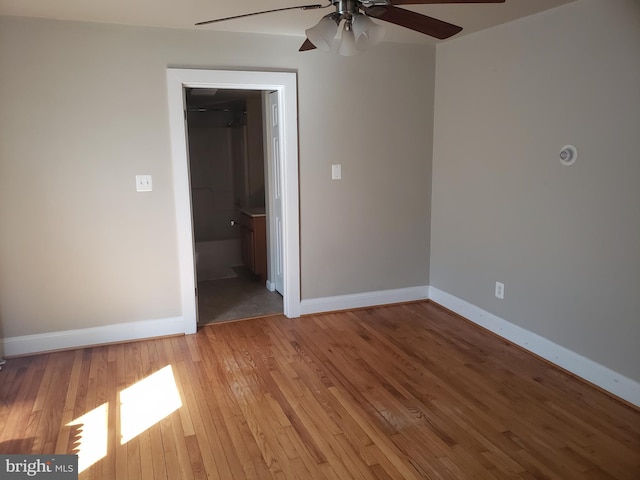 empty room with ceiling fan and light hardwood / wood-style floors