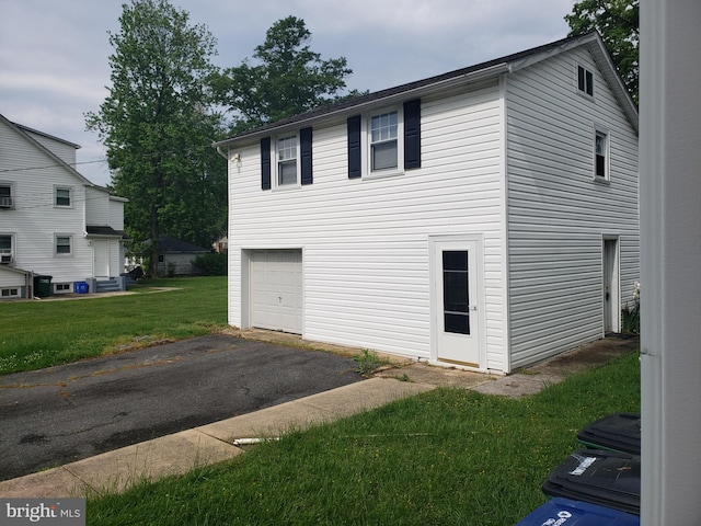 view of side of property featuring a garage and a yard