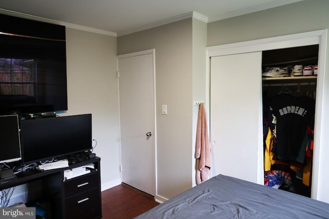 bedroom with dark hardwood / wood-style floors, crown molding, and a closet