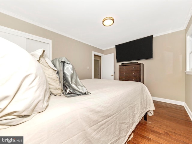 bedroom featuring wood-type flooring, a closet, and crown molding