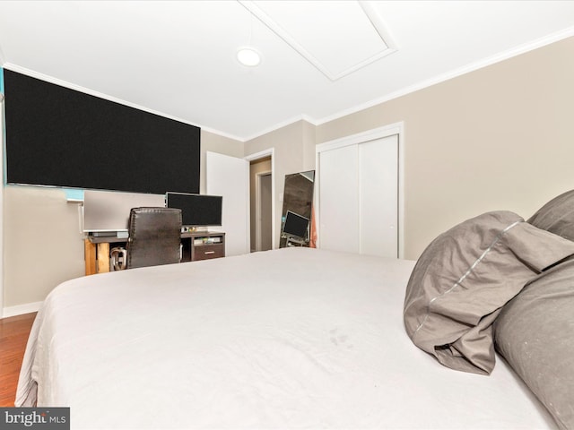 bedroom featuring wood-type flooring, a closet, and crown molding