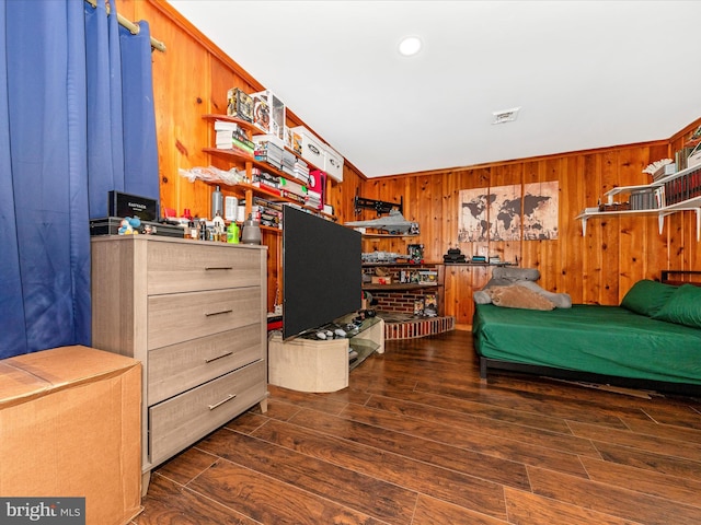 bedroom with wood walls and dark hardwood / wood-style floors