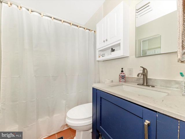 bathroom with tile patterned floors, backsplash, toilet, vanity, and tile walls