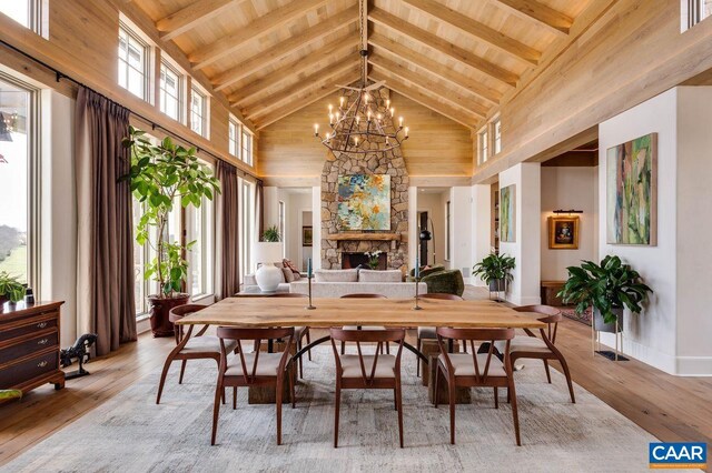 dining room with hardwood / wood-style flooring, beam ceiling, a chandelier, and high vaulted ceiling