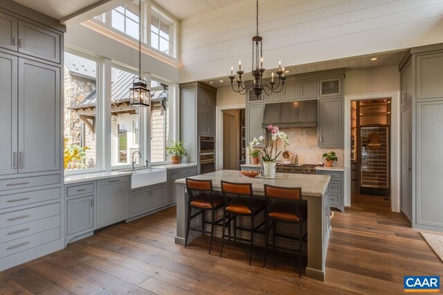 dining area with a notable chandelier, dark wood-type flooring, a healthy amount of sunlight, and sink