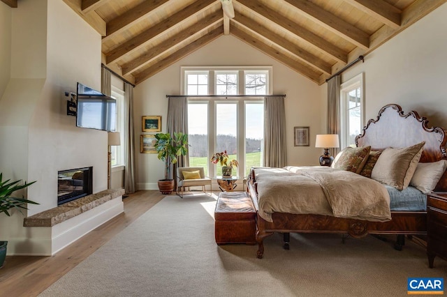 bedroom featuring wood-type flooring, beam ceiling, and multiple windows