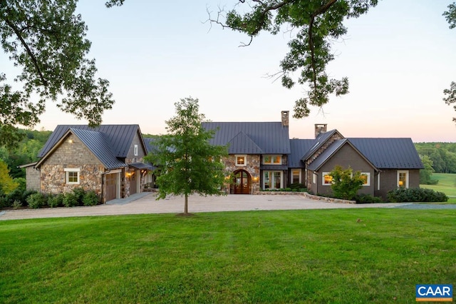 view of front of property with a garage and a yard