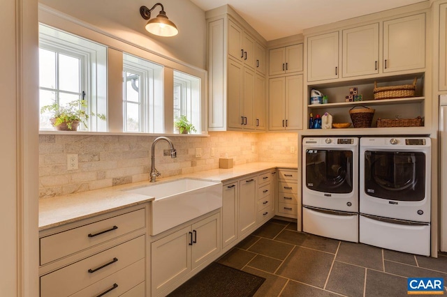 washroom featuring cabinets, dark tile patterned floors, washer and dryer, and sink