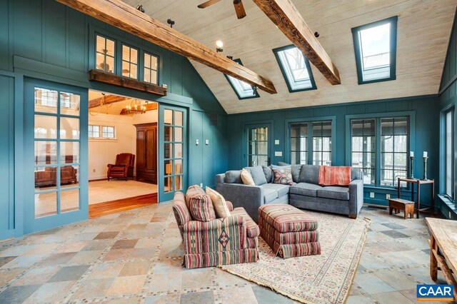 living room with high vaulted ceiling, a skylight, and plenty of natural light