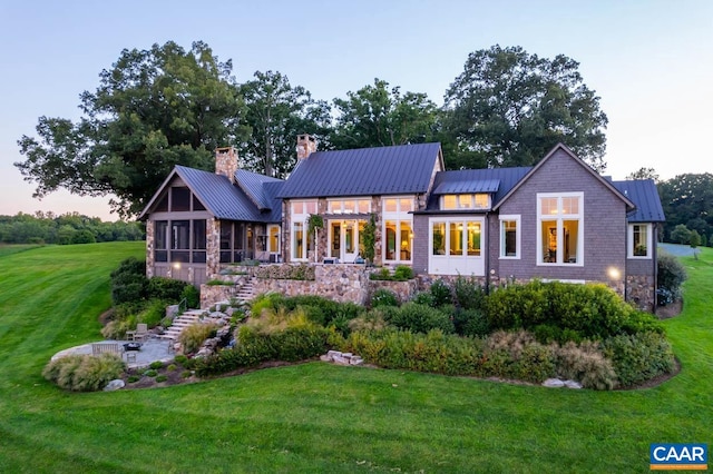 view of front of property featuring a sunroom and a lawn