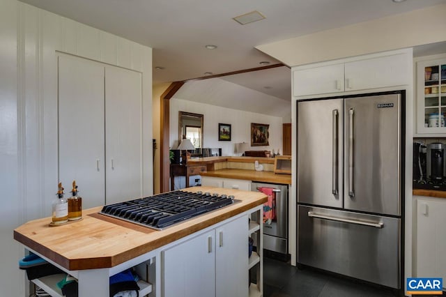 kitchen with white cabinets, beverage cooler, stainless steel appliances, a center island, and wood counters