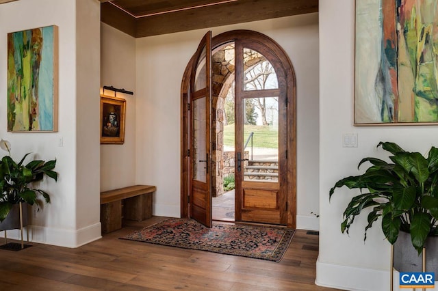 entryway featuring french doors, beamed ceiling, and dark wood-type flooring