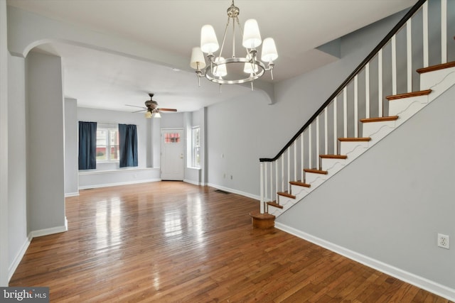 entrance foyer with ceiling fan with notable chandelier and hardwood / wood-style flooring