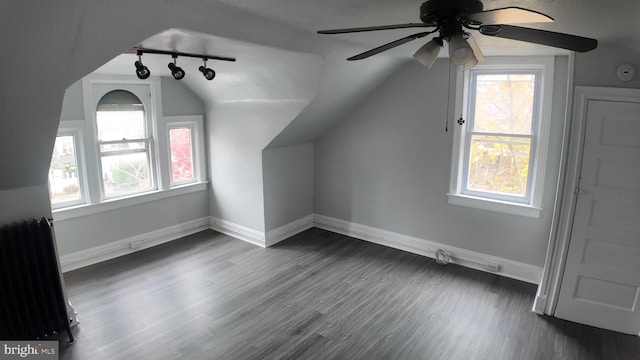 additional living space with radiator heating unit, dark hardwood / wood-style floors, ceiling fan, and lofted ceiling