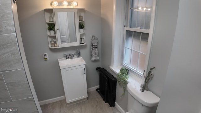 bathroom featuring vanity, toilet, and radiator heating unit