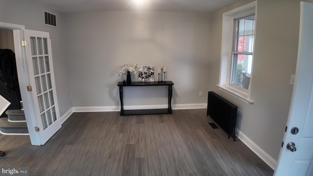 interior space with radiator heating unit and dark wood-type flooring