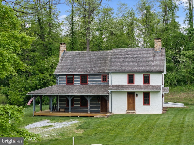 view of front of home with a wooden deck and a front lawn