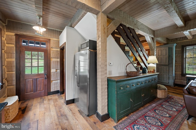 interior space featuring wooden ceiling, beam ceiling, wooden walls, and light hardwood / wood-style flooring