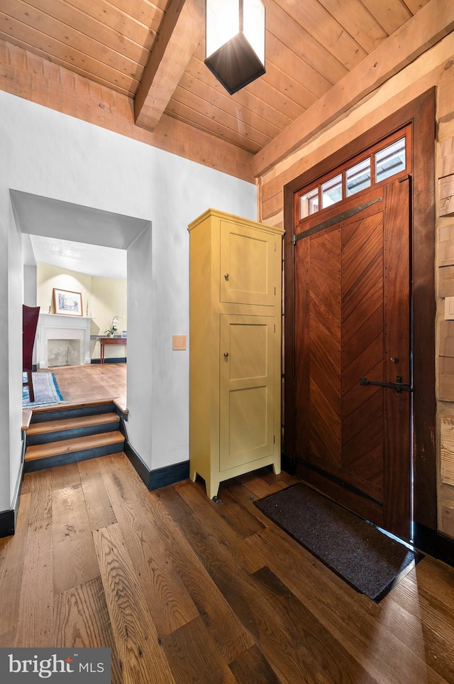 entryway with beamed ceiling, a fireplace, dark hardwood / wood-style floors, and wooden ceiling