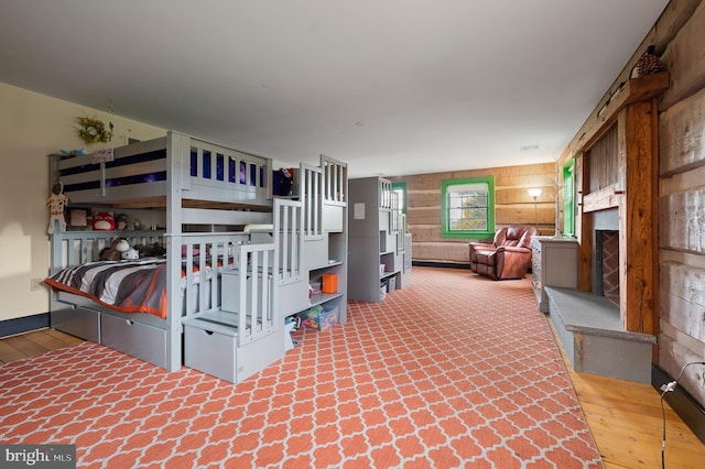 bedroom featuring wooden walls and hardwood / wood-style floors