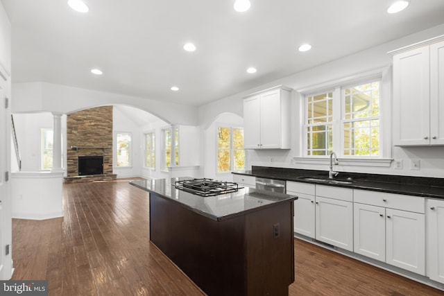 kitchen featuring white cabinetry, sink, appliances with stainless steel finishes, a kitchen island, and dark hardwood / wood-style flooring