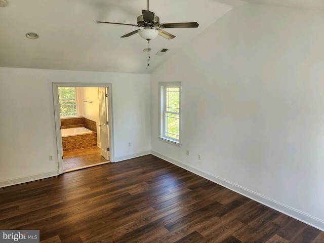 unfurnished bedroom with lofted ceiling, multiple windows, and dark hardwood / wood-style flooring