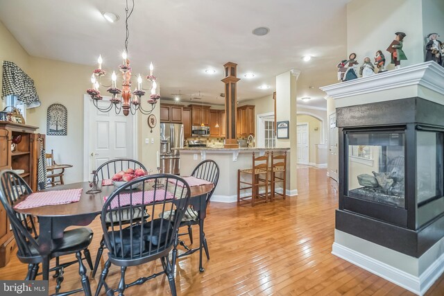 dining space with an inviting chandelier and light wood-type flooring