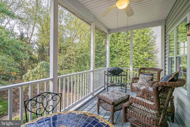 sunroom featuring ceiling fan and plenty of natural light