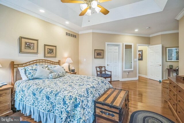 bedroom featuring ceiling fan, light wood-type flooring, and crown molding