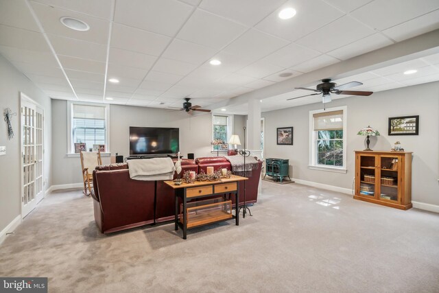 carpeted living room with ceiling fan, a healthy amount of sunlight, and a paneled ceiling