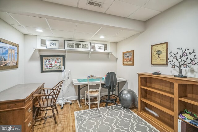 office area with hardwood / wood-style flooring and a paneled ceiling