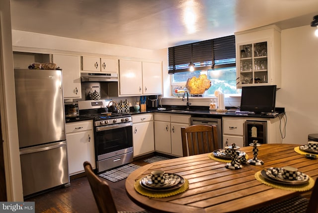 kitchen with white cabinetry, appliances with stainless steel finishes, sink, and dark hardwood / wood-style flooring