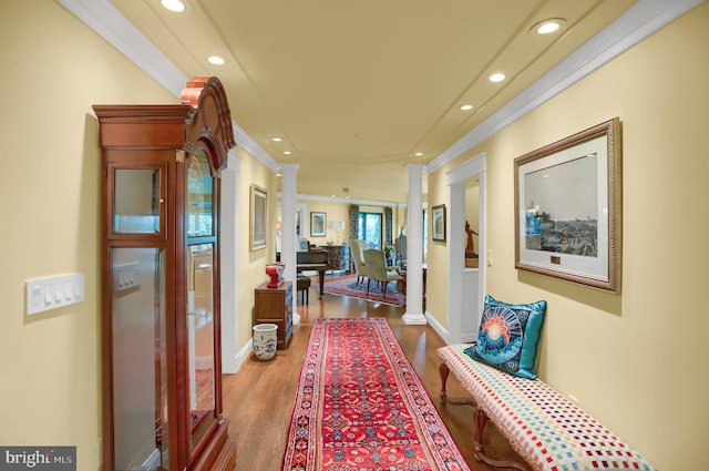 corridor with hardwood / wood-style floors, decorative columns, and crown molding