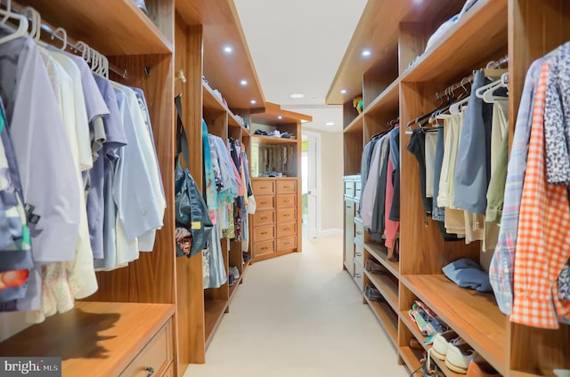 walk in closet featuring light carpet