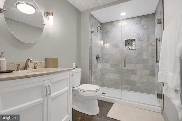 bathroom with a shower with door, vanity, and toilet