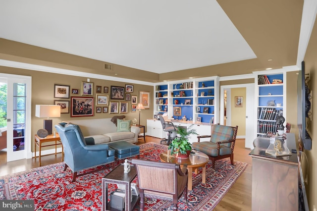 living area featuring wood finished floors and built in shelves