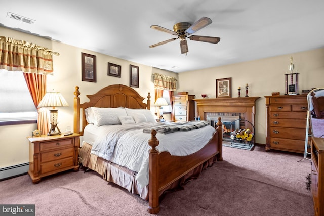 carpeted bedroom with a baseboard heating unit and ceiling fan