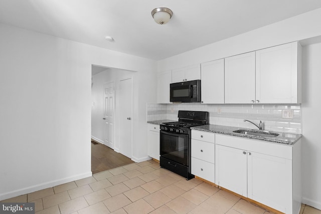 kitchen with dark stone countertops, white cabinets, sink, and black appliances