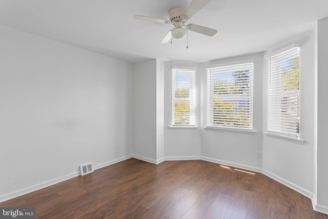 spare room with dark wood-type flooring and ceiling fan