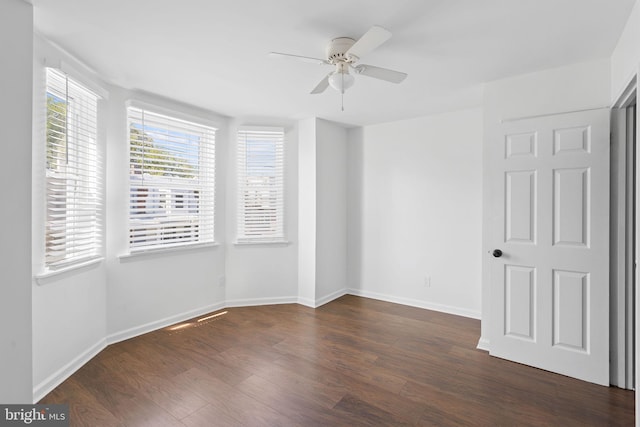 empty room with ceiling fan, dark hardwood / wood-style floors, and a healthy amount of sunlight