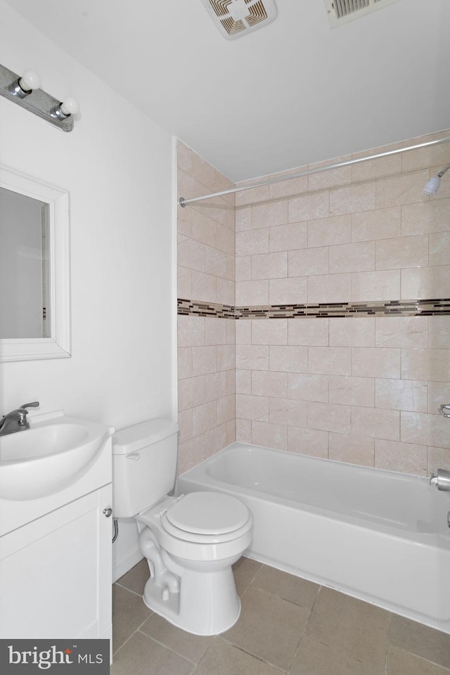 full bathroom featuring tiled shower / bath, vanity, toilet, and tile patterned floors